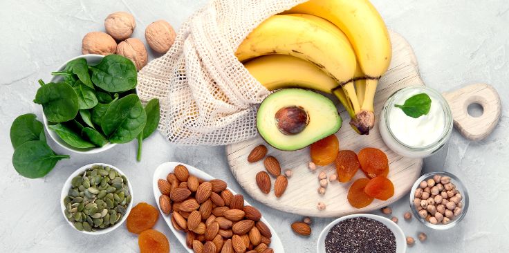 a variety of healthy foods rich in magnesium, including bananas, avocado, spinach, almonds, and seeds.