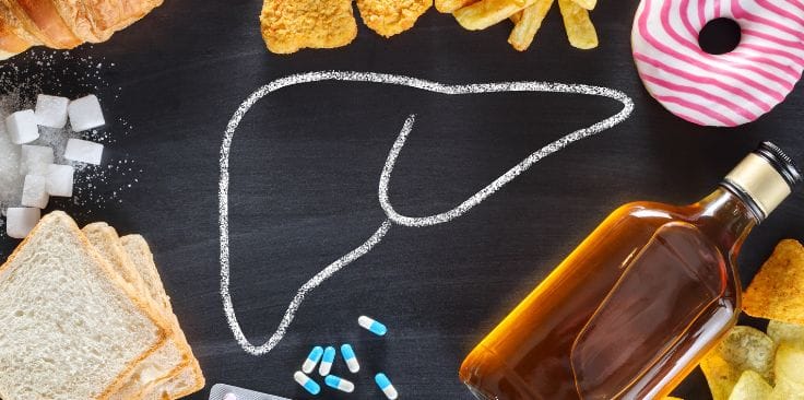 Chalk outline of a liver surrounded by unhealthy foods, alcohol, and pills on a black background.