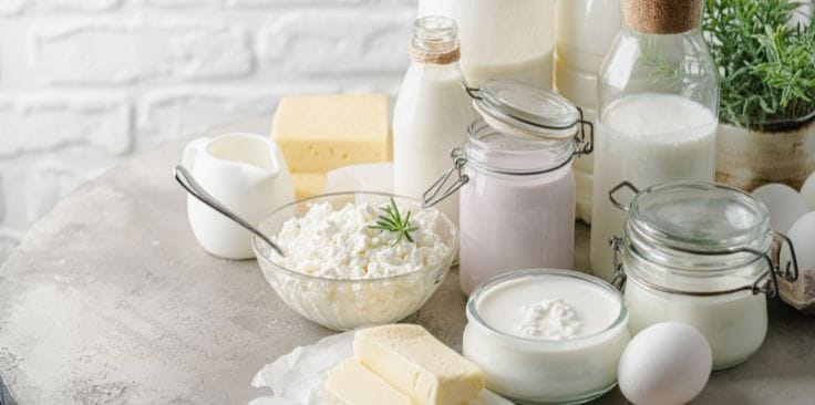 Various dairy products in jars and bowls on a table.