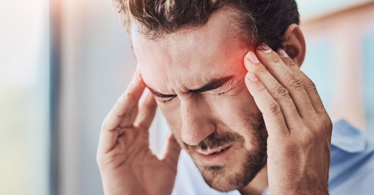 Man holding his temples, experiencing intense headache pain.