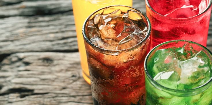 Colorful soda drinks with ice in glasses.