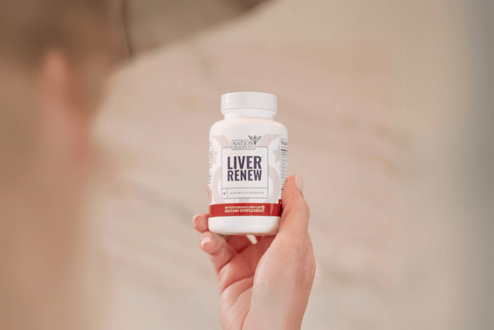 hand holding a bottle of "Liver Renew" by Nation Health MD against a blurred, neutral background.