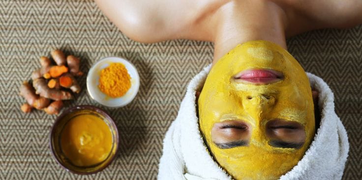 A person with a turmeric face mask, showcasing what does turmeric do for your skin in promoting a glowing and nourished appearance.