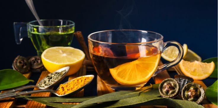 Hot turmeric tea with lemon slices, spices, and herbs, showcasing what is turmeric tea good for in wellness.