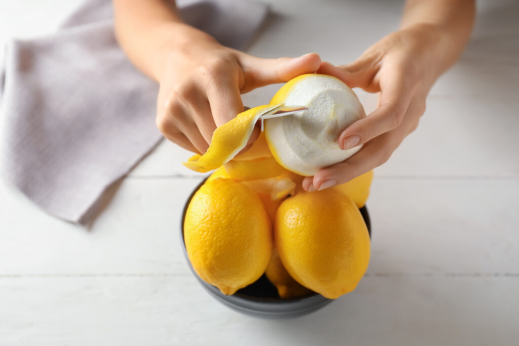 Image shows how a lemon is being peeled.